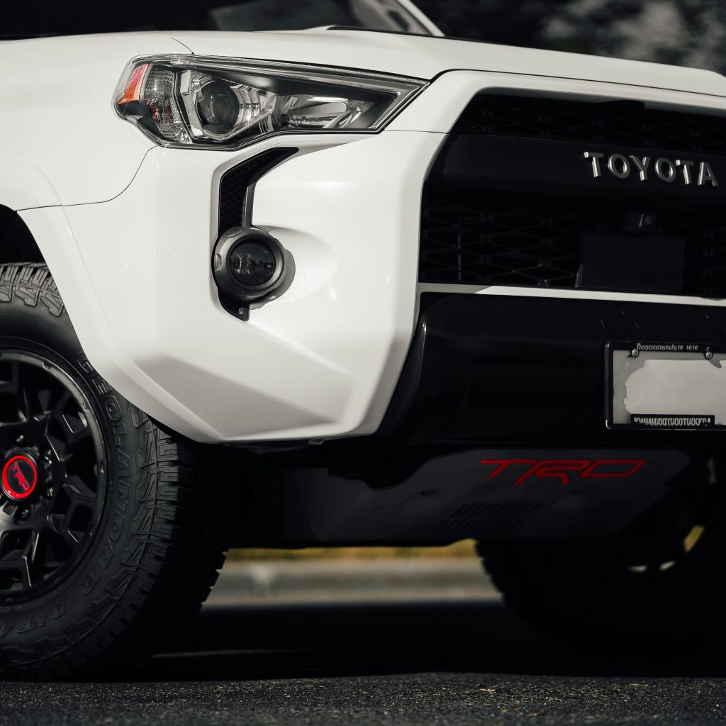 Detailed shot of a white SUV front bumper and tire for rugged adventures.