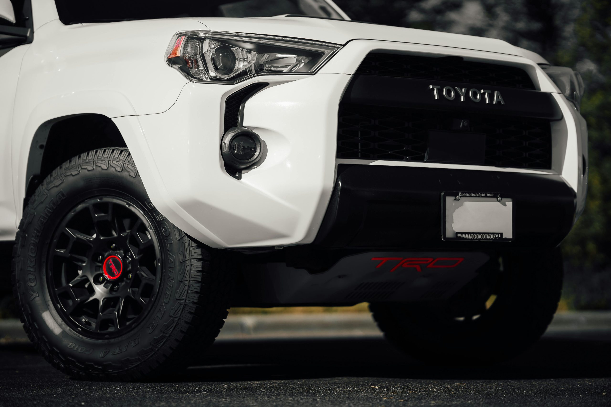 Detailed shot of a white SUV front bumper and tire for rugged adventures.